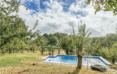 a swimming pool in a field with a tree at 1 Bedroom Stunning Home In Galicia in Belesar