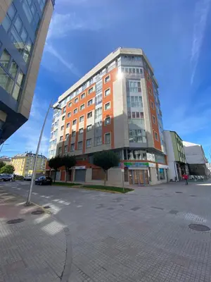 a tall building in a city with a parking lot at dpCristal Calvo Sotelo 164, 4D in Sarria