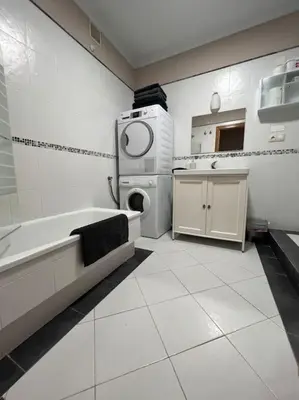 a white bathroom with a sink and a washing machine at Apartamento Cantabrico vistas a la Ría deRibadeo in Ribadeo