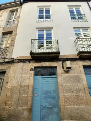 a building with a blue door and a balcony at Apartamentos SARABIA DARRIBA in Ourense