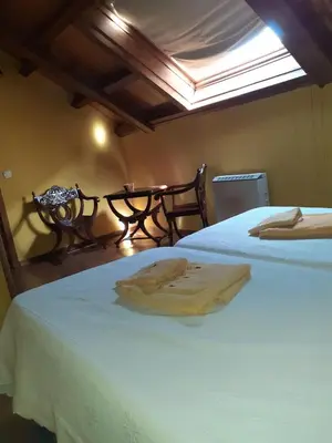 a bedroom with two beds and a table with a window at OSO3 in Pola de Somiedo