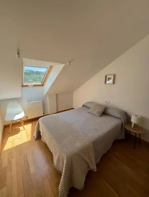 a bedroom with a large bed with a window at PortoHome 2 in Portomarin