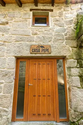 a stone building with a door with a sign above it at Casa pepe in Nogueira de Ramuin
