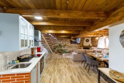 an open kitchen and living room with wooden ceilings at Casapepe in Nogueira de Ramuin