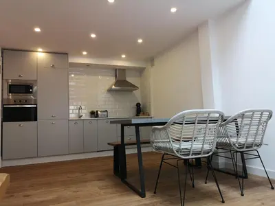 a kitchen with a table and two chairs at Cabanela Maitia Jacuzzi privado y barbacoa in Ribadeo