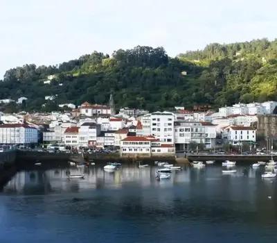 a city with boats in the water and a bridge at Adiva Suite in Puentedeume