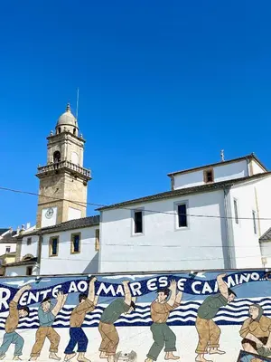 a mural on the side of a building with a clock tower at The Cliffs A Ribeira - Peizas in Foz