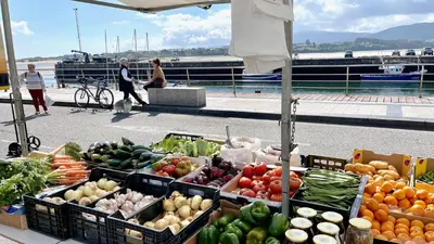 a farmers market with fruits and vegetables on a boat at The Cliffs A Ribeira - Peizas in Foz