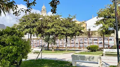 a park with benches and trees in front of a building at The Cliffs A Ribeira - Peizas in Foz