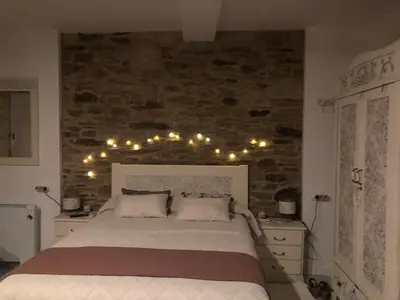 a bedroom with a bed with lights on the wall at Estudios rúa Maior, 49-2B in Sarria