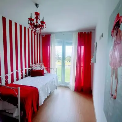 a bedroom with red and white striped walls and a bed at Apartamento con piscina in Barreiros