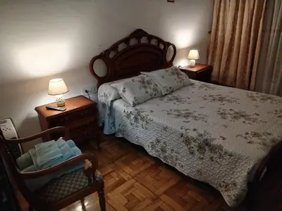 a bedroom with a bed and two chairs and two lamps at Casa Albergue PTY in Sarria