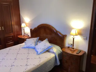 a bedroom with a bed with blue pillows and two lamps at Casa Cancelas in Santiago de Compostela