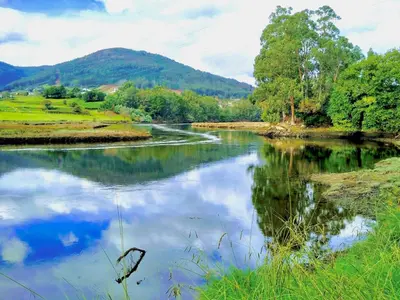 a river with a reflection of the sky in the water at The Cliffs - AT Seiramar in Viveiro