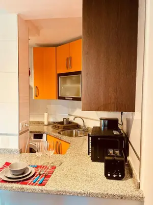 a kitchen with orange cabinets and a counter with plates and glasses at House Borba Foz in Foz