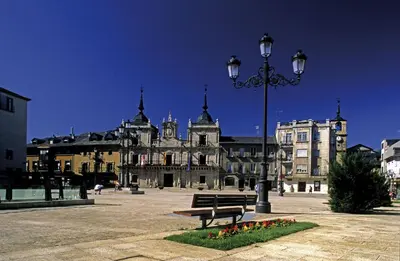 a street light and a bench in front of a building at BierzINN Alojamientos - Martina in Ponferrada