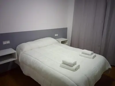 a white bed with two towels on top of it at Road in Palas de Rei