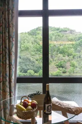 a bottle of wine and a basket of fruit in front of a window at Albariño in Pincelo