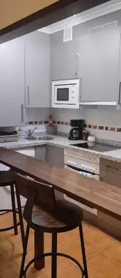 a kitchen with a wooden table and a microwave at La Vega De Somiedo 2 in Pola de Somiedo