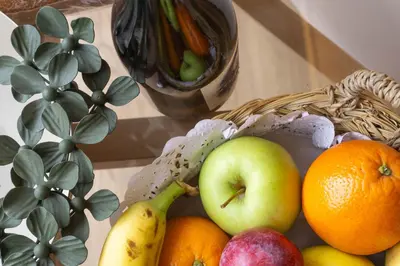 a basket of fruit on a table next to a plant at Treixadura in Pincelo