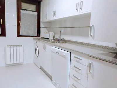 a white kitchen with white cabinets and a sink at Figueras 3 in figueras