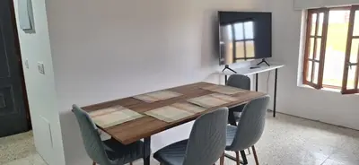 a dining room table with chairs and a television at Casa Julia in Barreiros