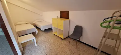 a room with two beds and a desk and a ladder at Casa Julia in Barreiros