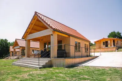 a small wooden house with a porch and stairs at Cabañas de Allariz in Allariz
