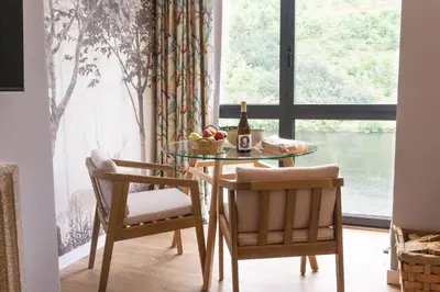 a dining room table with two chairs and a bottle of wine at Caño in Pincelo