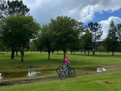 a woman riding a bike in a park at Casa Aldea de Piñeiro, Turismo Rural Padrón by URent in Padrón