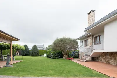 a backyard of a house with a lawn at apartamento 1 matrimonial con terraza acristalada in Tapia de Casariego