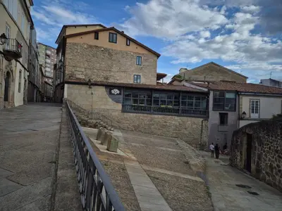 an empty street in a city with a building at Escola in Ourense