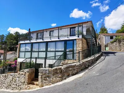 a large house with a stone wall at Alojamientos as moras arans in La Cañiza