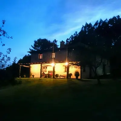 a house lit up at night with lights at Casa Carballeira in Villarfernando