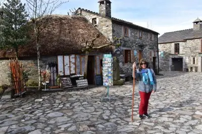 a woman holding a stick in front of a building at Stone Cottage O CEBREIRO in Curtis