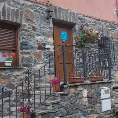 a stone building with potted plants on a balcony at Casa Antonio y Benina in Sosas de Laciana