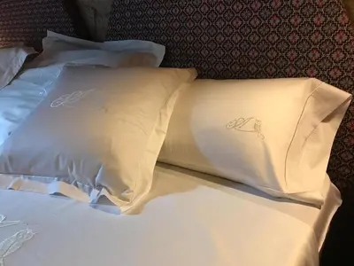 a bed with two white pillows on it at San Andres Ferienhaus mit Gästehaus in Parada del Sil