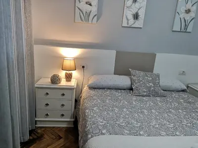 a bedroom with a bed and a nightstand with a lamp at Piso Camino de Santiago 2 in Sarria