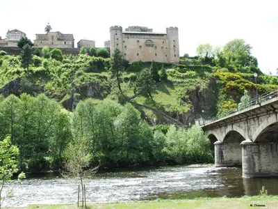 a bridge over a river with a castle in the background at El Relax de Sanabria in Trefacio