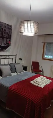a bedroom with a bed with a red blanket at María Belkis in Ourense