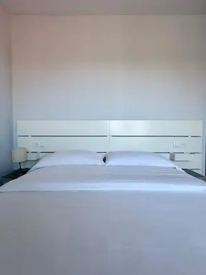 a large white bed in a white bedroom at Lemos Nube in Monforte de Lemos