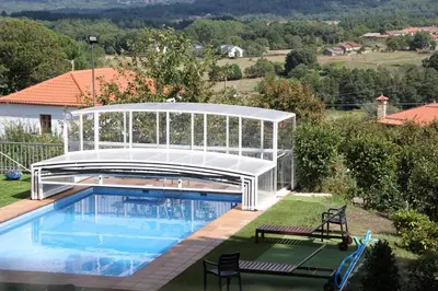 a swimming pool with a pavilion next to a house at A Forxa - Casa Ferrador (Ribeira Sacra) in Sober