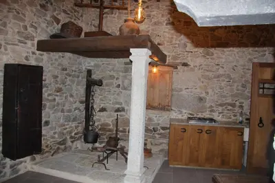 a kitchen with a stone wall with a stone stove at A Forxa - Casa Ferrador (Ribeira Sacra) in Sober