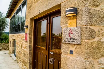 a stone building with a door and a sign on it at O Forno - Casa Ferrador (Ribeira Sacra) in Sober
