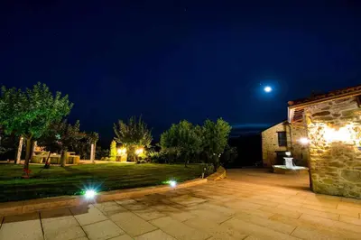 a night view of a house with the moon in the sky at O Forno - Casa Ferrador (Ribeira Sacra) in Sober