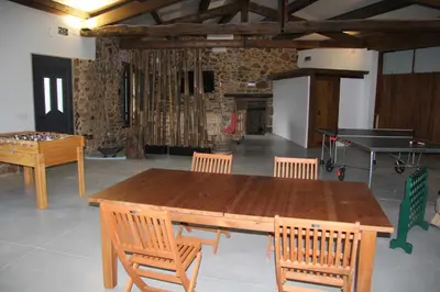 a ping pong table and chairs in a room with a ping pong ball at O Forno - Casa Ferrador (Ribeira Sacra) in Sober