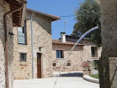 a building with a water hose in front of it at O Forno - Casa Ferrador (Ribeira Sacra) in Sober