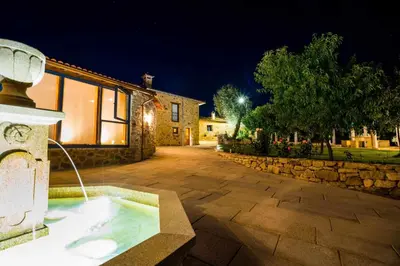 a hot tub in the middle of a yard at night at O Fogón - Casa Ferrador (Ribeira Sacra) in Sober