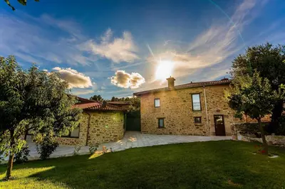 a brick house with the sun in the sky at O Yunque - Casa Ferrador (Ribeira Sacra) in Sober