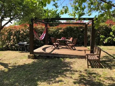 a wooden deck with a table and chairs in a garden at Ribeira Sacra II - Ourense in Nogueira de Ramuin
